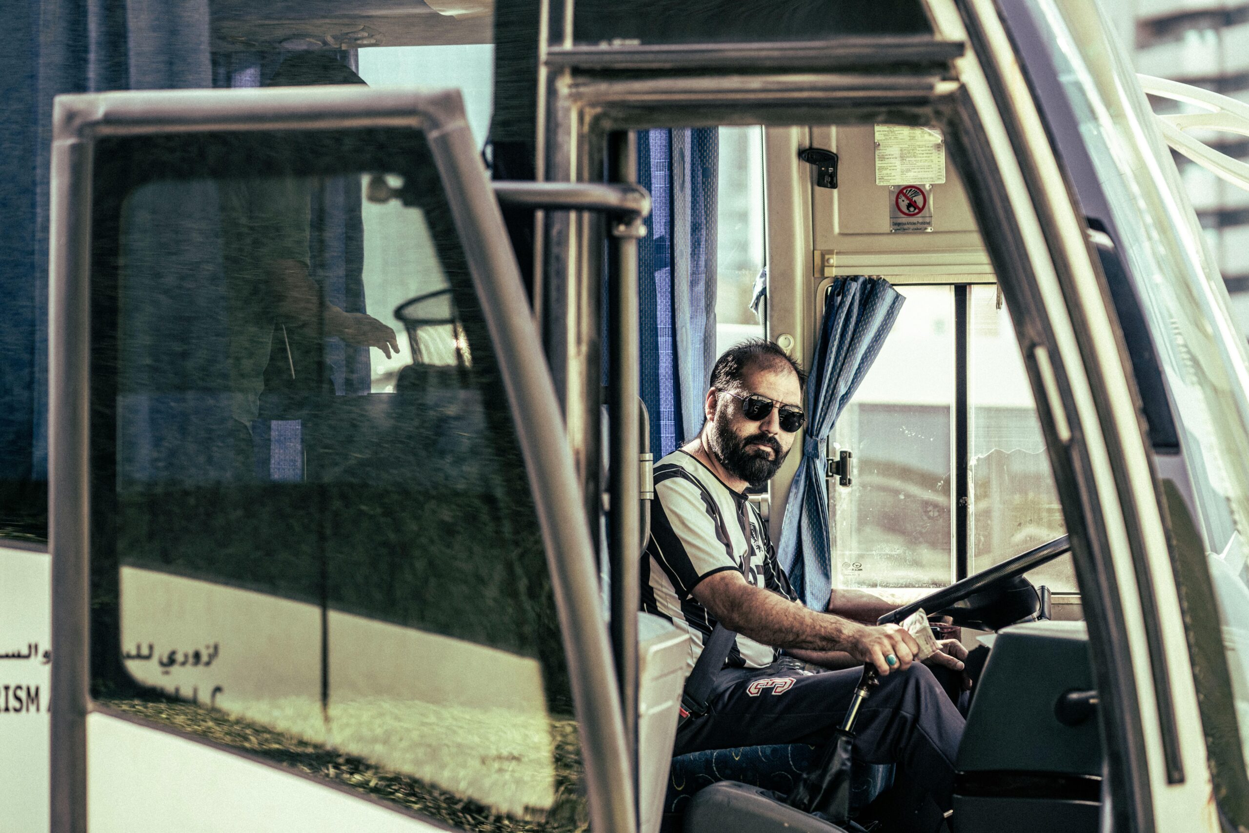how to plan charter bus trip NYC in 2025: Your Essential Smart Guide 2 Confident bus driver in sunglasses sits behind the wheel, ready for travel.
