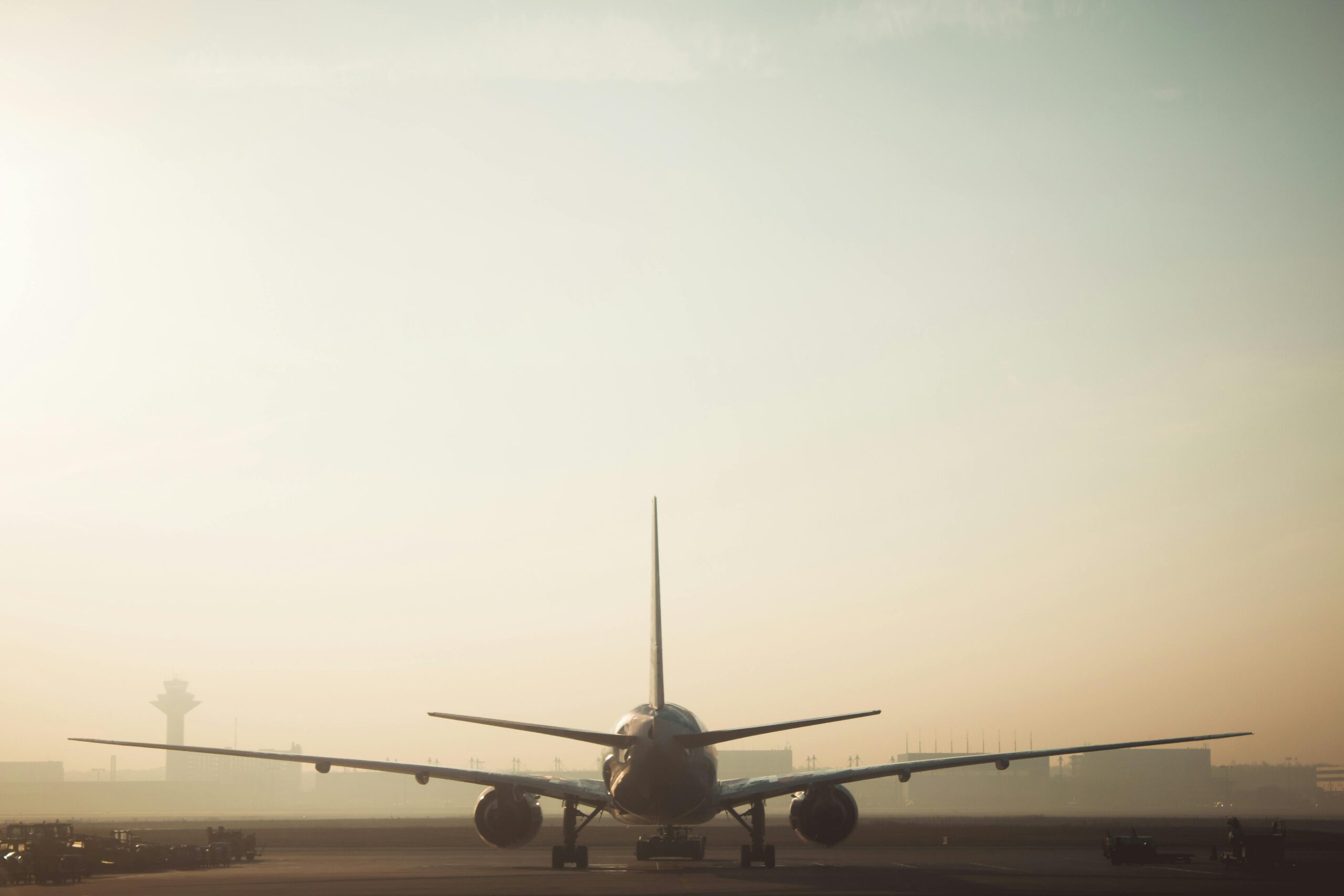 Group Shuttle LGA Pickup in 2025: Your Ultimate Guide to Conquering NYC Airport Chaos 4 A misty morning scene of a plane on the runway with a hazy sky background, showcasing air travel ambiance.