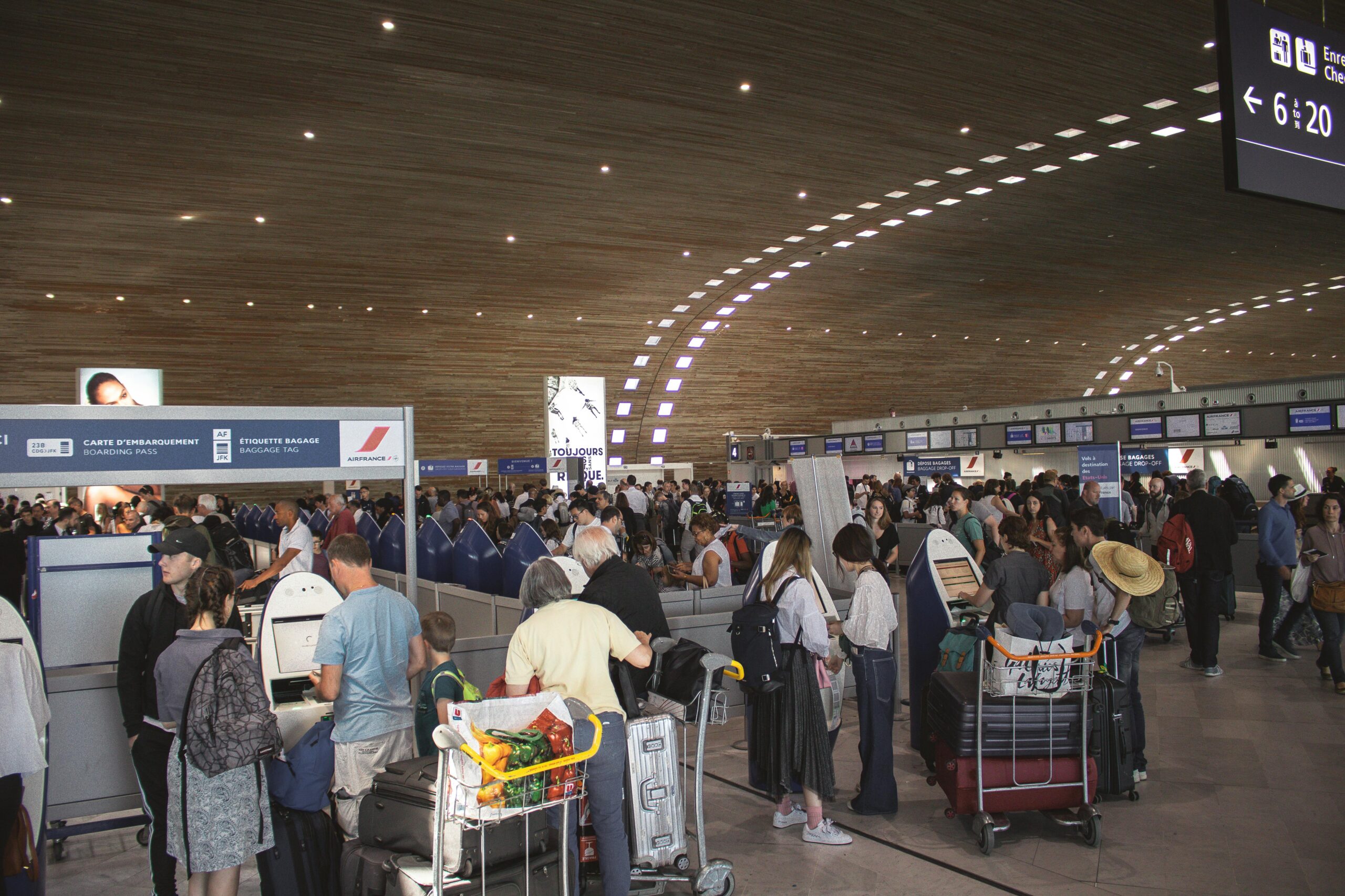 LGA Shuttle App Booking: The Ultimate 2025 Guide to NYC Airport Transfers 2 Crowded airport terminal with travellers in line. Indoor setting with modern architecture.