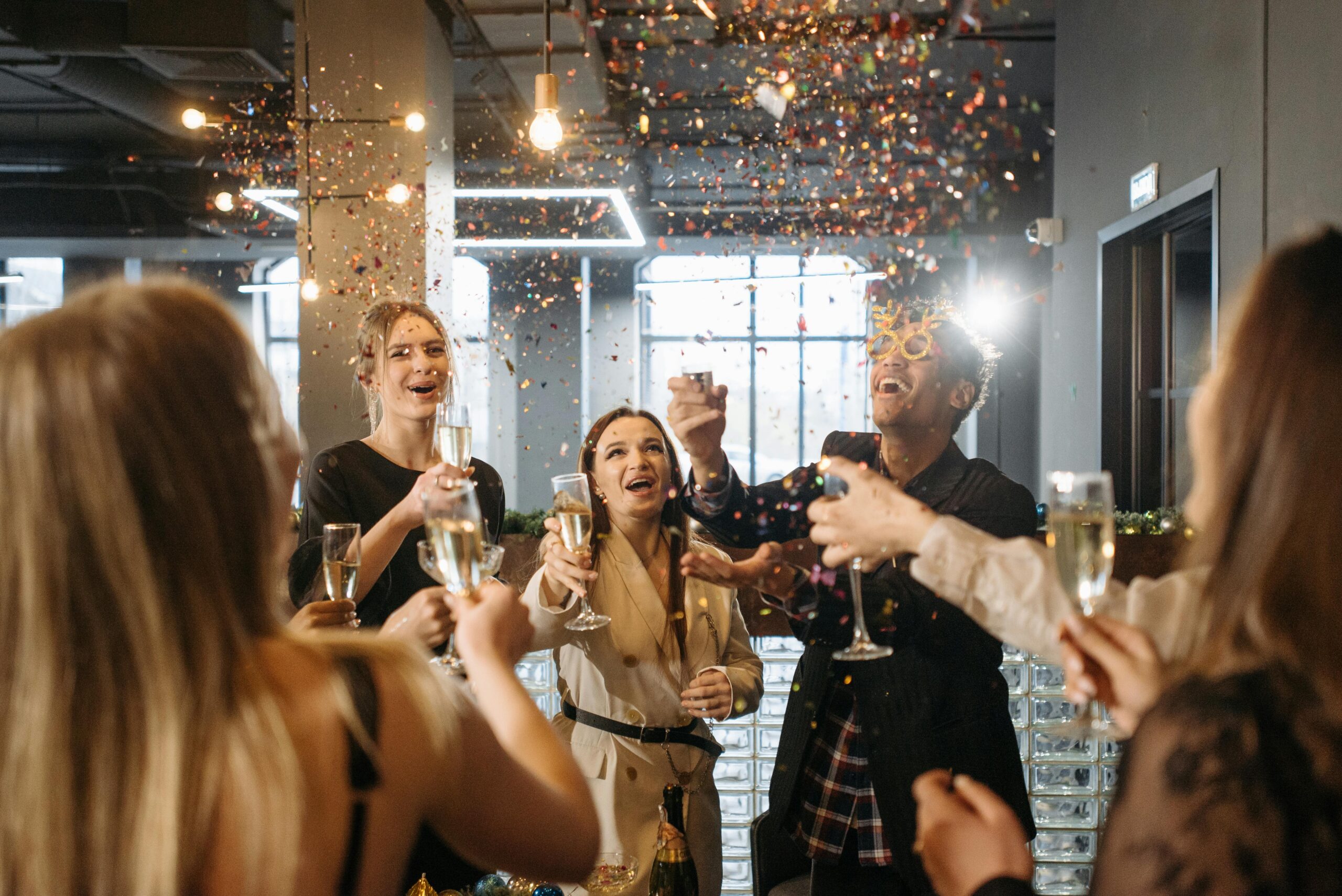 Eco-Friendly Party Bus NYC: Sustainable Swag for Your Big Night in 2025 6 A group of friends celebrates indoors with champagne and confetti in a festive atmosphere.