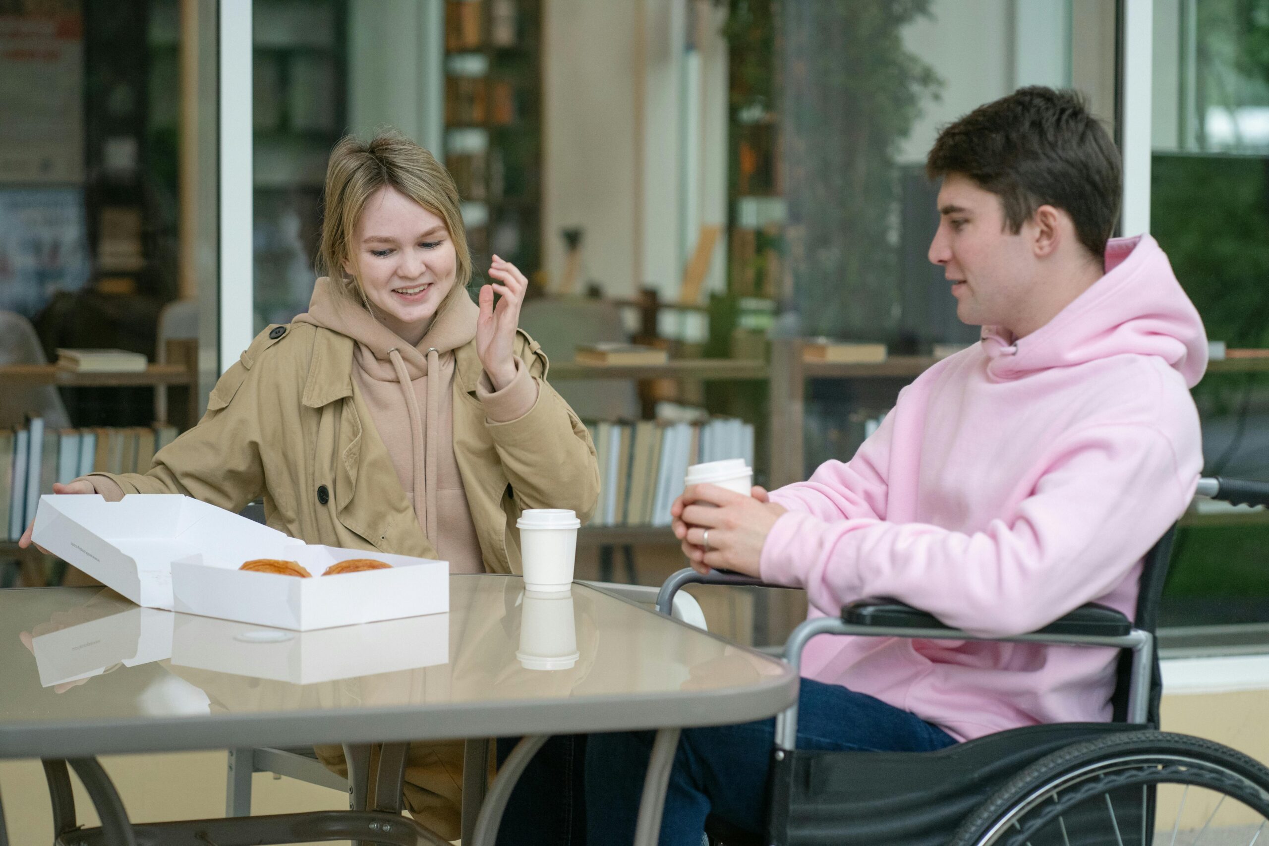 Wheelchair Accessible Wedding Buses NYC in 2026: Making Your Day Truly Inclusive 9 A couple sitting at an outdoor café table enjoying coffee and pastries in a relaxed setting.