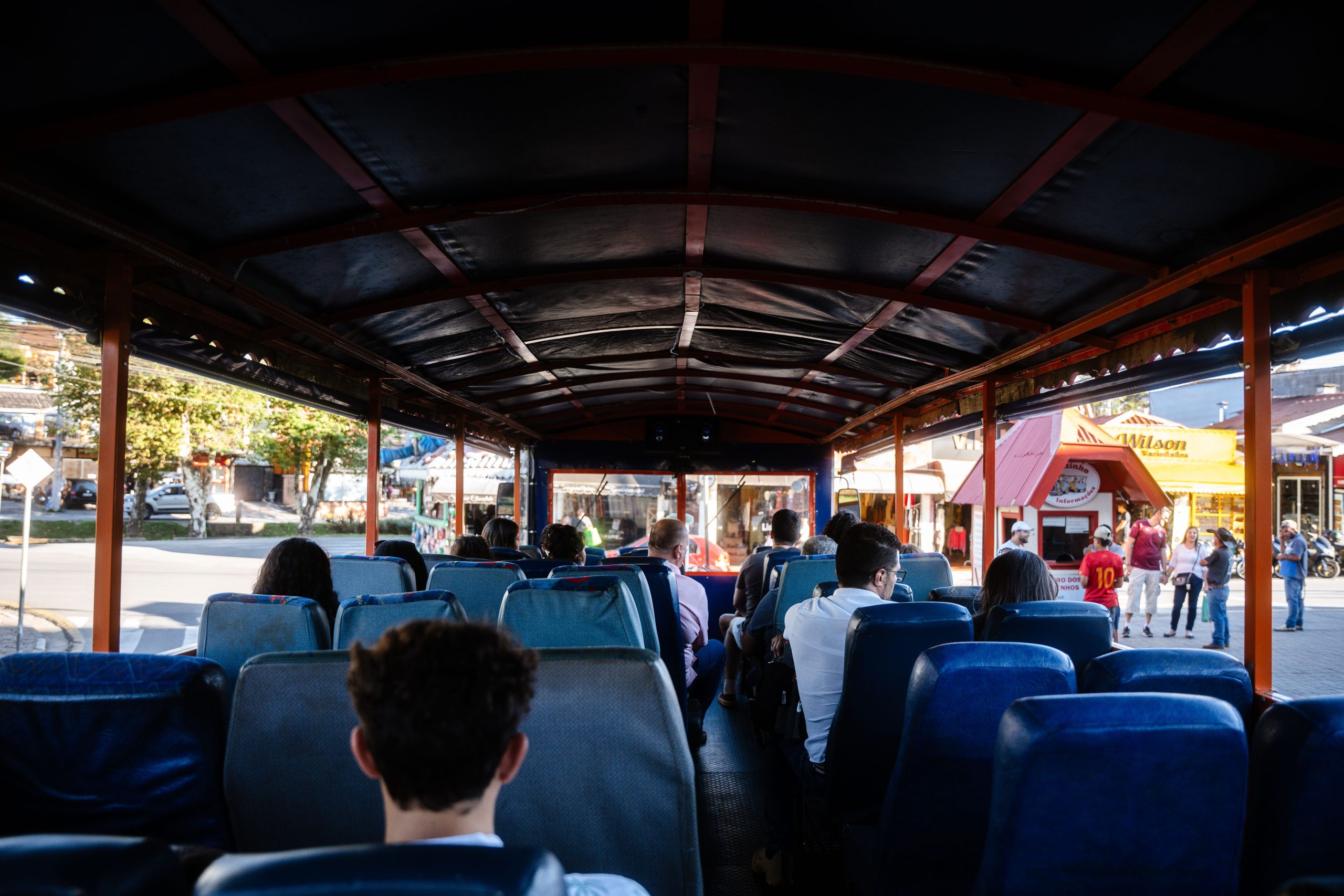 Group Tour Transportation in NYC: A 2026 Survival Guide for Moving Your Crew 2 Passengers on an open-top bus enjoying a city tour in Campos do Jordão, Brazil.