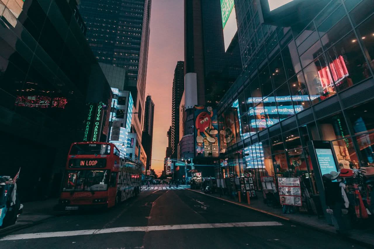 Dynamic NYC street scene with skyscrapers and traffic at dusk.